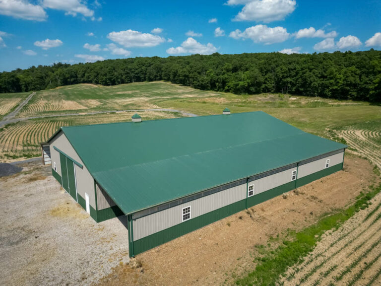 Top view of a barn with an evergreen standing seam roof and clay siding